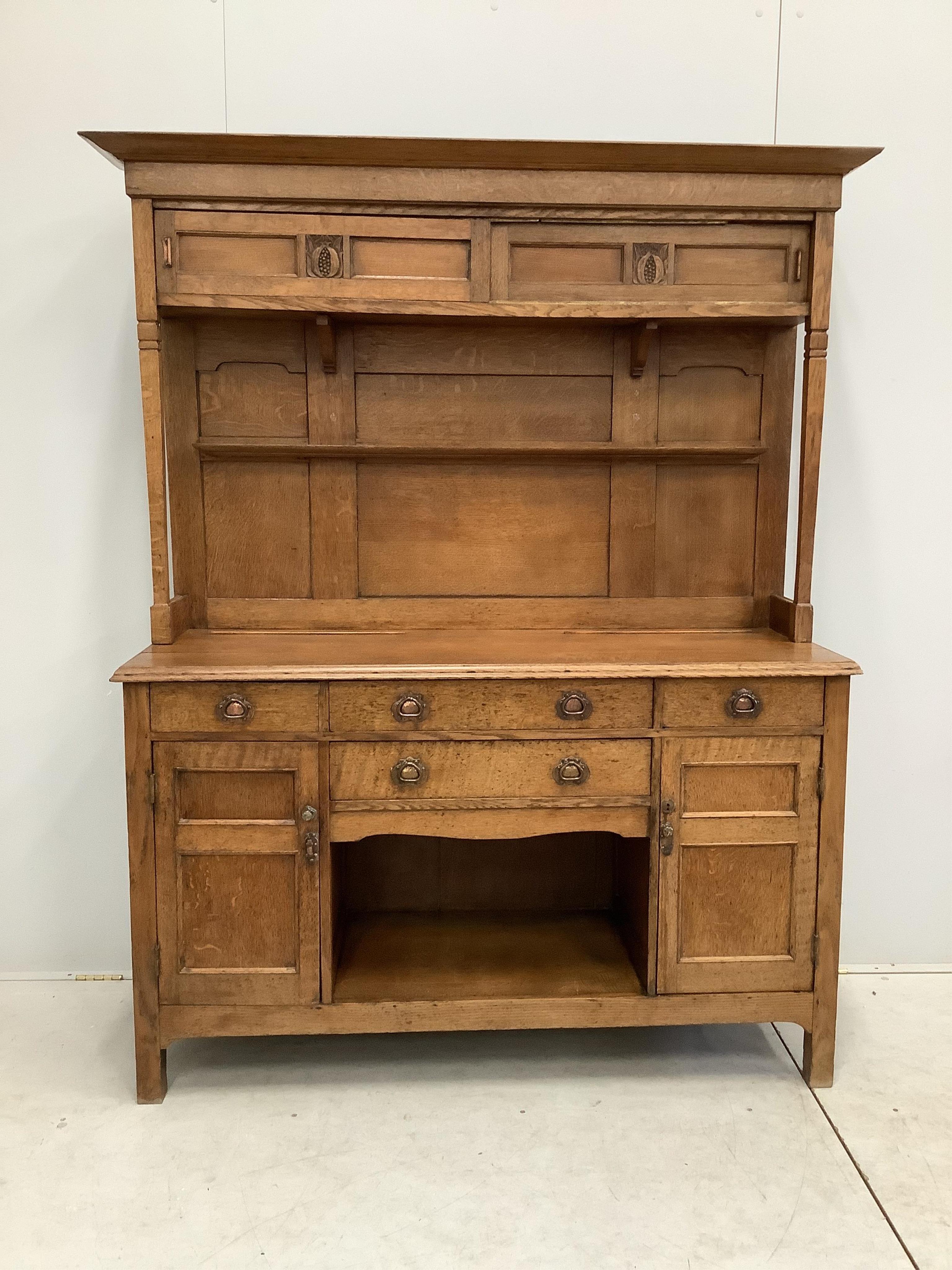 A small Arts & Crafts copper mounted oak dresser, width 140cm, depth 48cm, height 182cm. Condition - fair